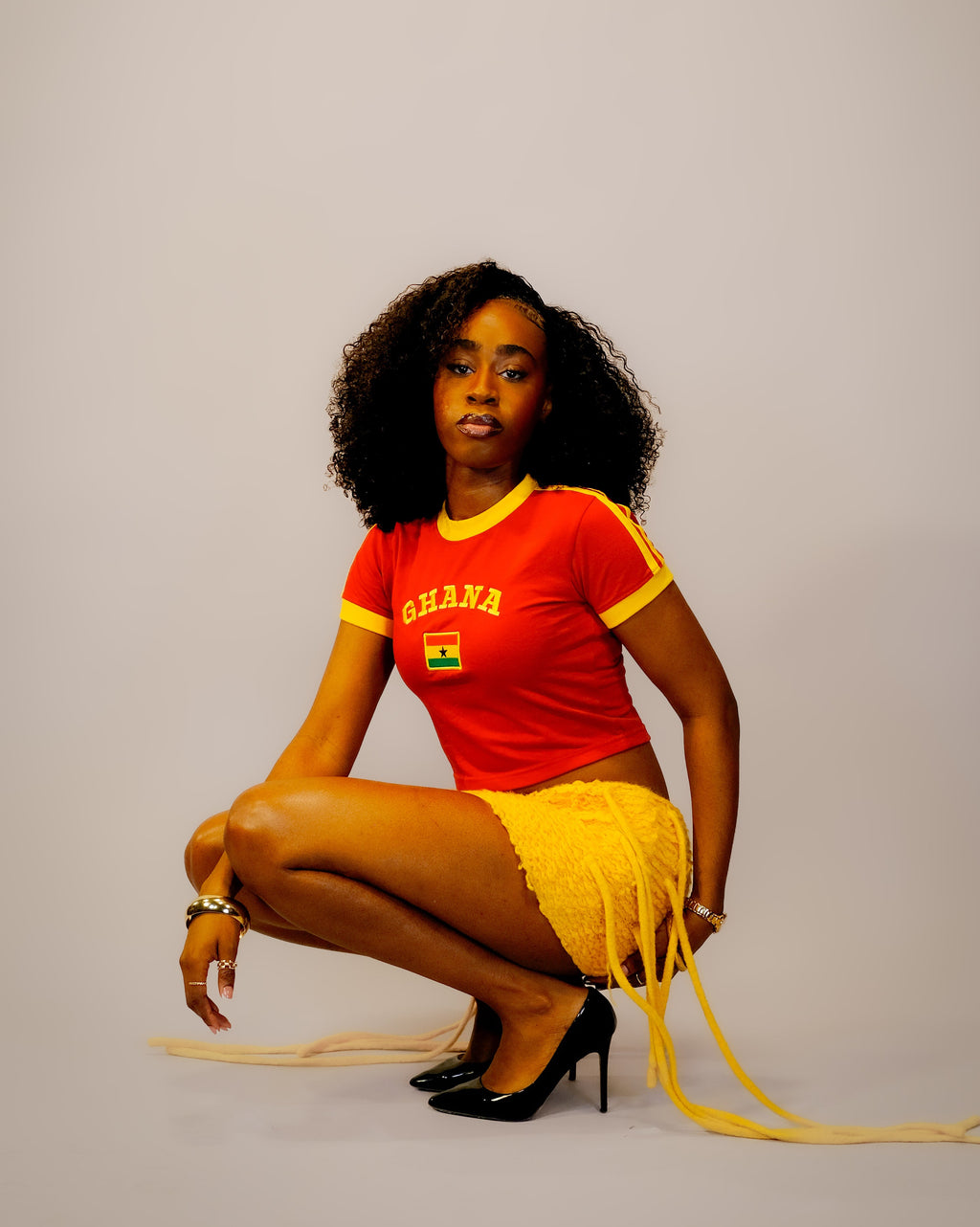 Woman wearing a red 'Ghana' t-shirt with yellow accents,