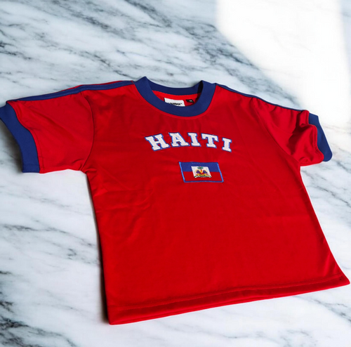 Red Haiti Baby Tee with blue stripes, haitian flag centered with curved white "HAITI" outlined in blue 