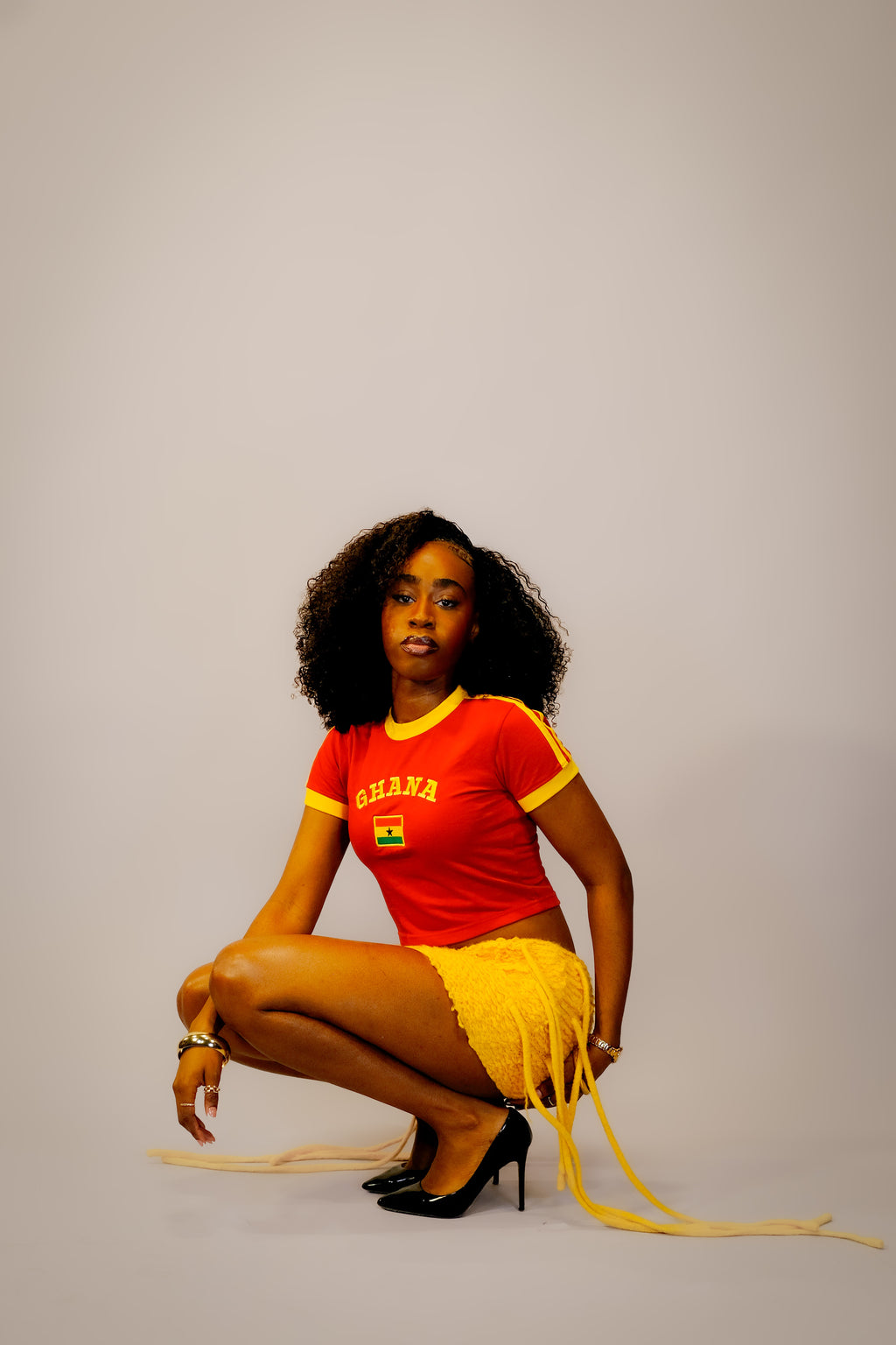 Woman wearing a red 'Ghana' t-shirt with yellow accents,